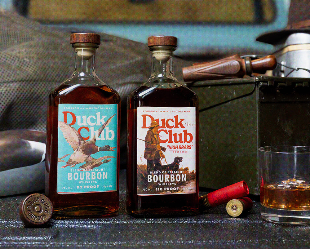 Bourbon bottles and a glass arranged on a sporting table