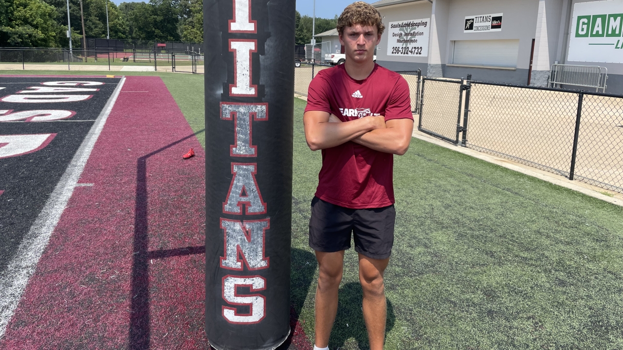 Quarterback Sam Sollie standing beside a Gadsden City goal post pad